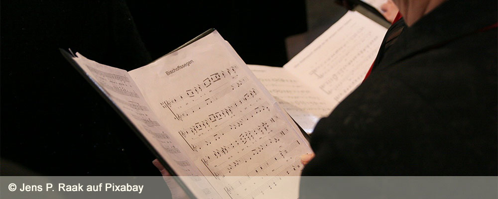 Notenblätter in den Händen von Chorsängern